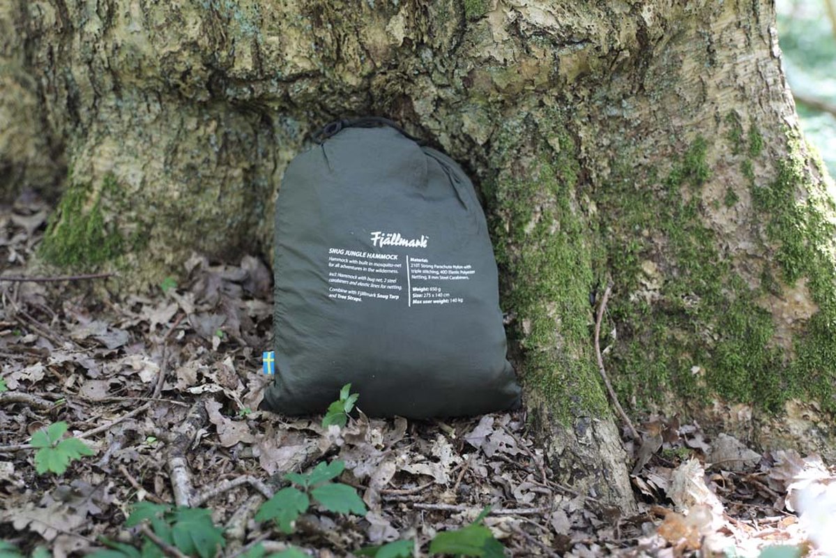Sammanpackad Fjällmark Snug Hammock i dragsåspucka mot trädstam