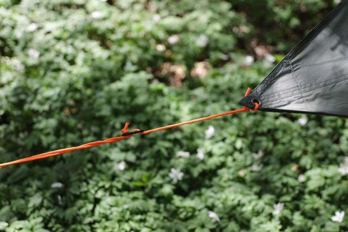Närm vy av mörkgrön Fjällmark-diagonal tarp med ögla och orange stormlina