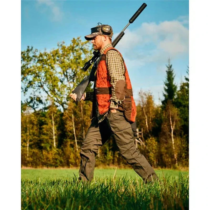 Jägare i mörkgröna InsectSafe byxor med gevärslåda i skogsmiljö