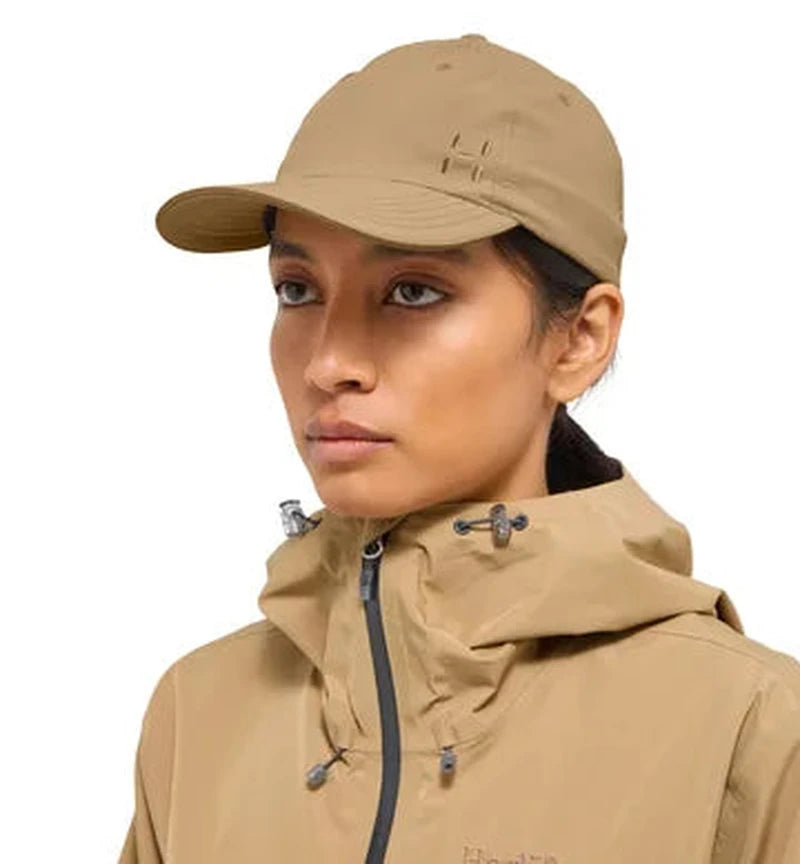 Kvinna bär beige Haglöfs Equator III keps med matchande jacka