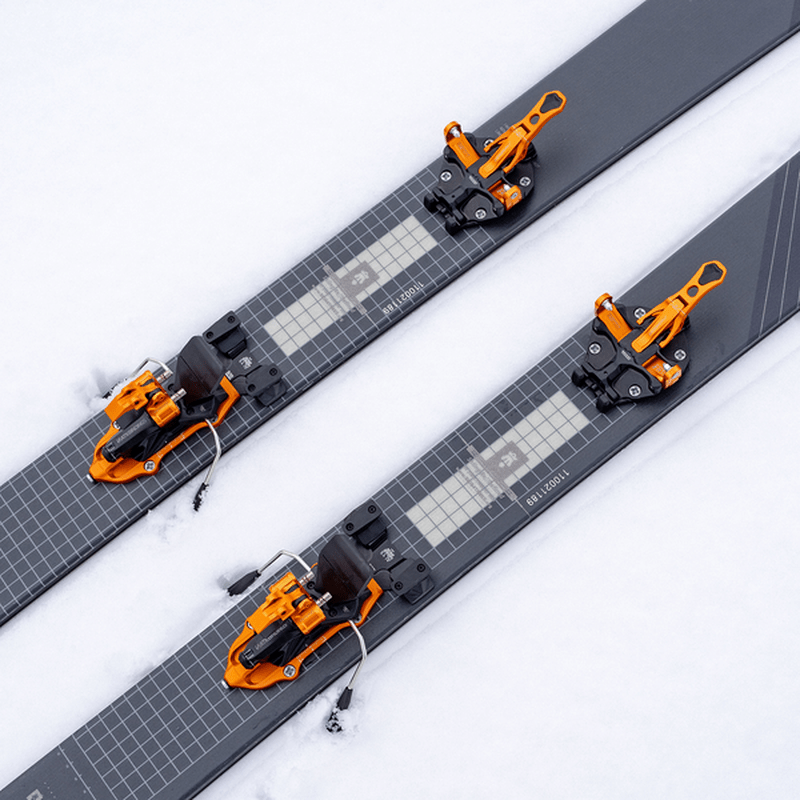 Översikt över orange ATK Freerider 15 EVO bindningar på skidor i vit snö