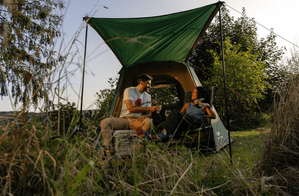 FastPitch Forest Lodge 4 campingtält i mörkgrönt med markis, utomhus vid gräs