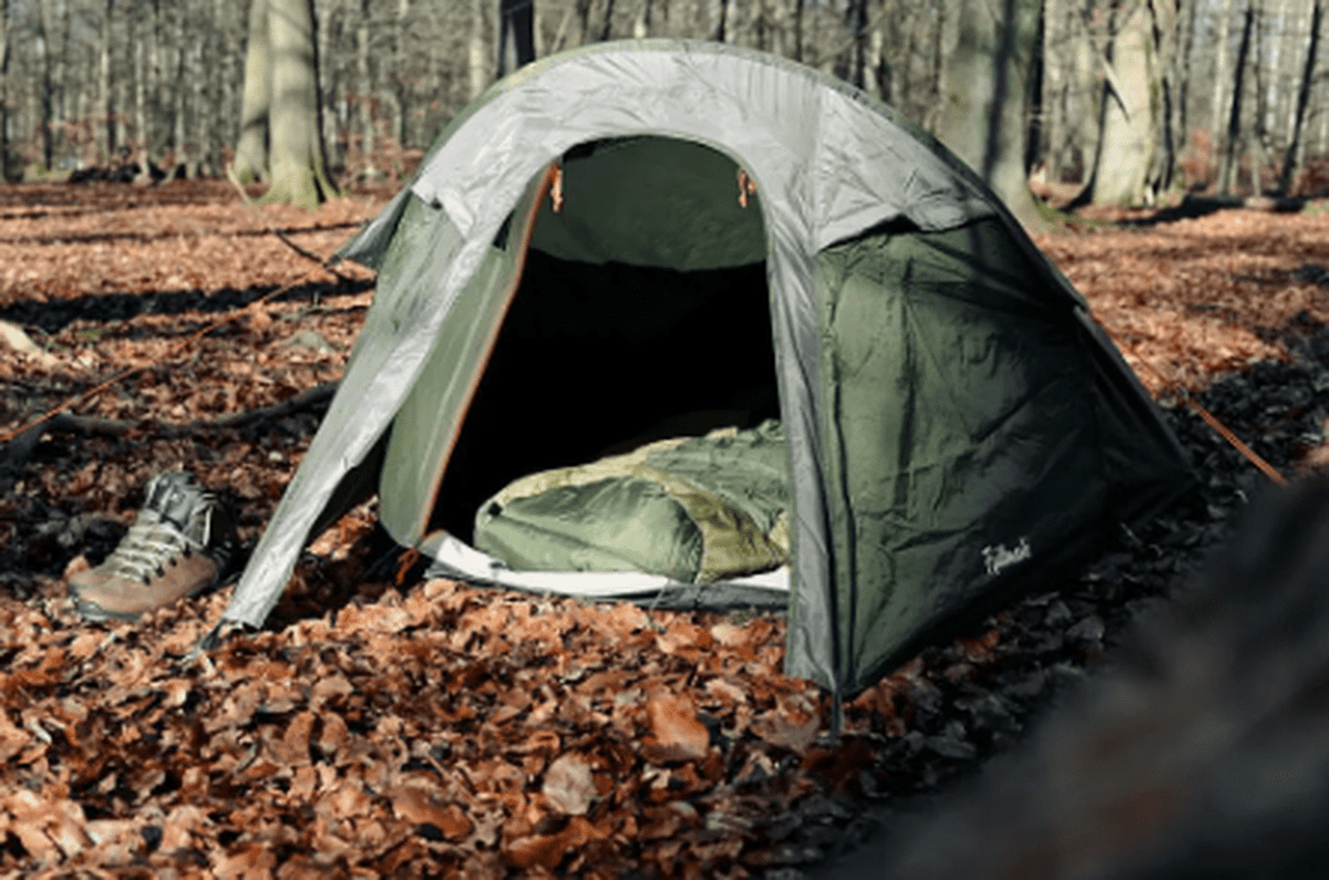Öppet Fjällmark Jeke tält i skog med sovsäck
