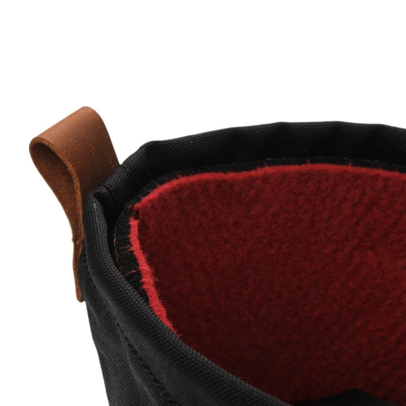 Detalj av rött foder och brun rem på insidan av svarta vinterkängor