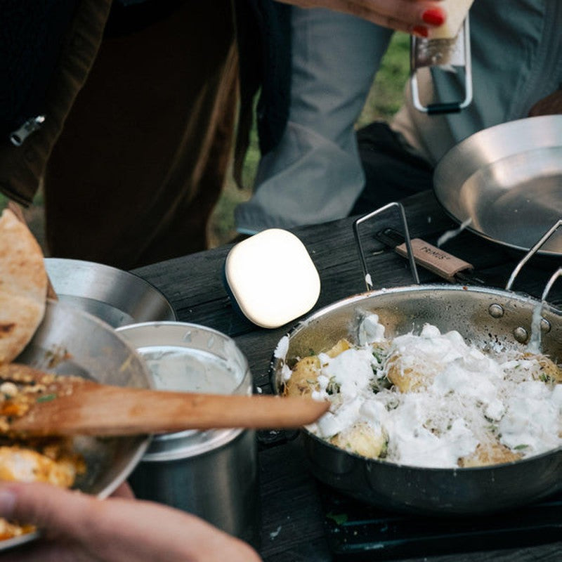 Vit Glow-ficklampa på bord vid utomhusmiddag