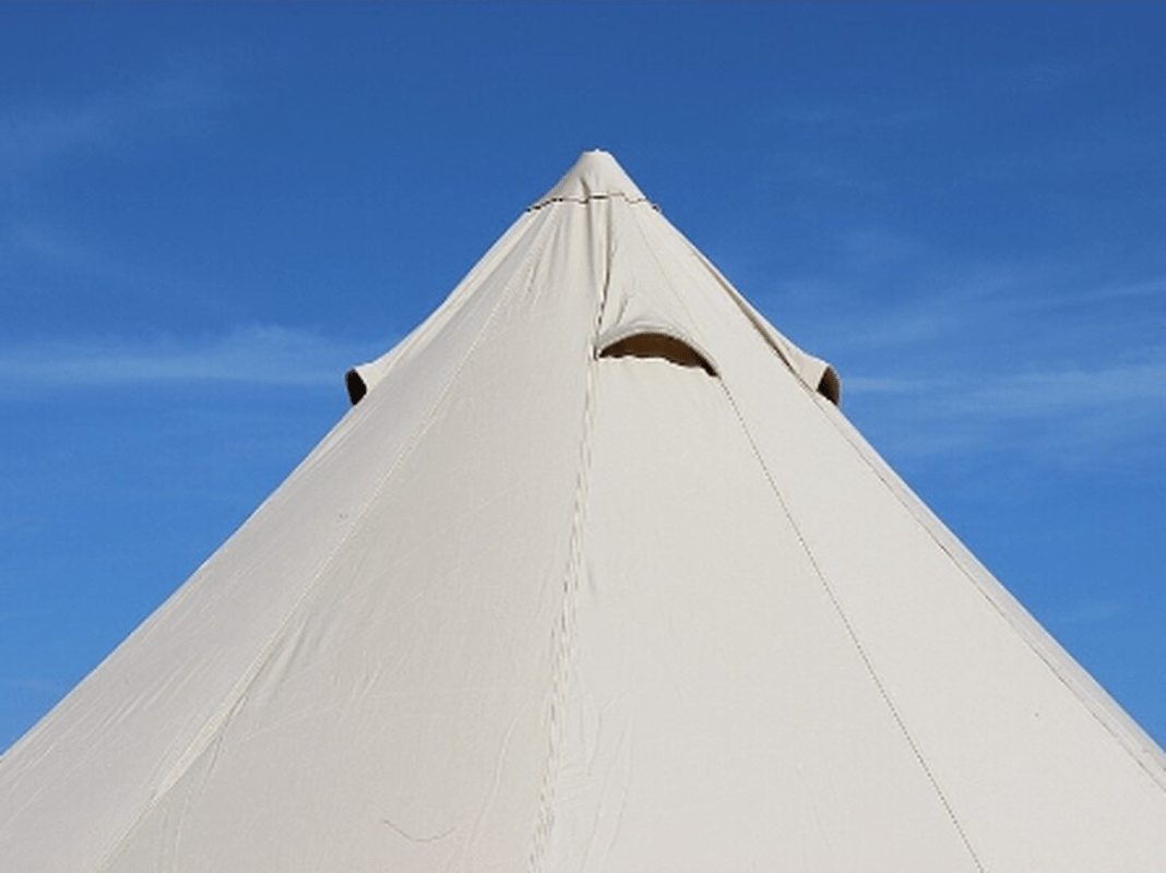 Tälttopp med ventilationslucka mot blå himmel
