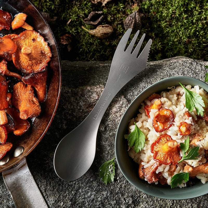 Rostfri spork vid utomhusmatning med stekpanna och ris
