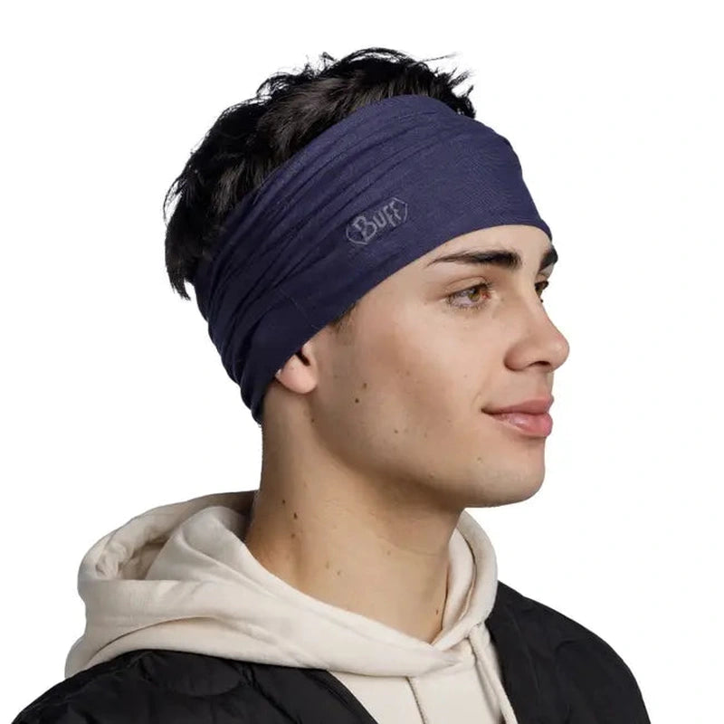 Man som bär mörkblå Buff Original Ecostretch som huvudband