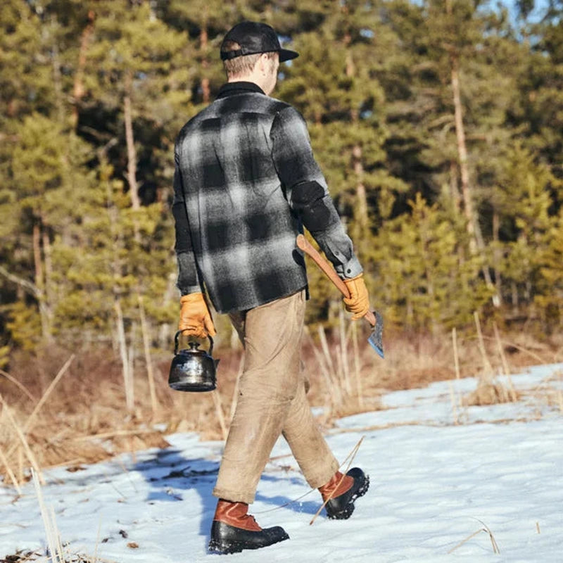 Man vandrar i snöskog med Graninge vandringskängor beige byxor