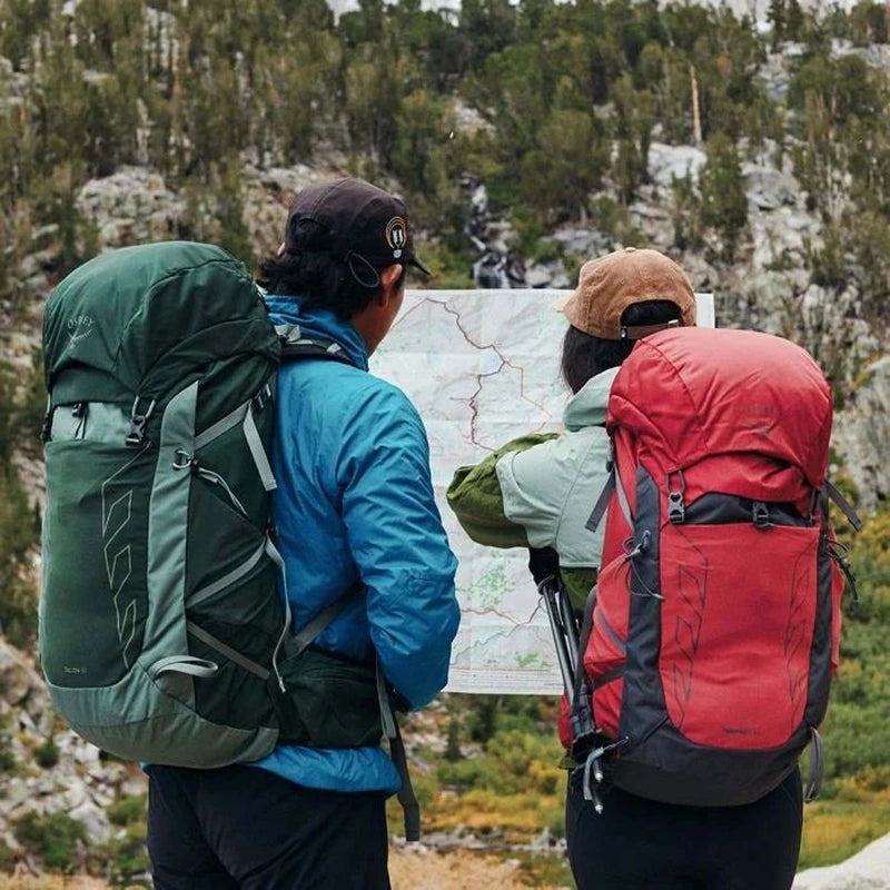 Osprey Talon 33 ryggsäck i mörkgrön och röd på vandrare i berg