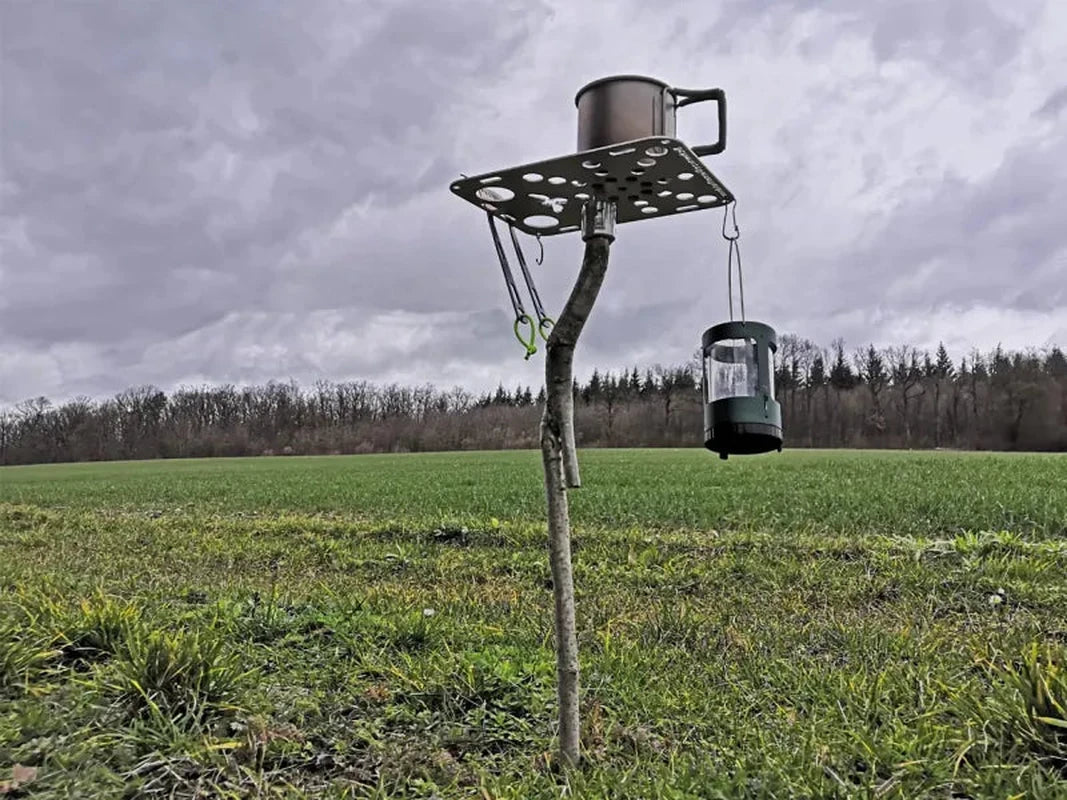 Campingbord monterat på trärot i skogsmiljö