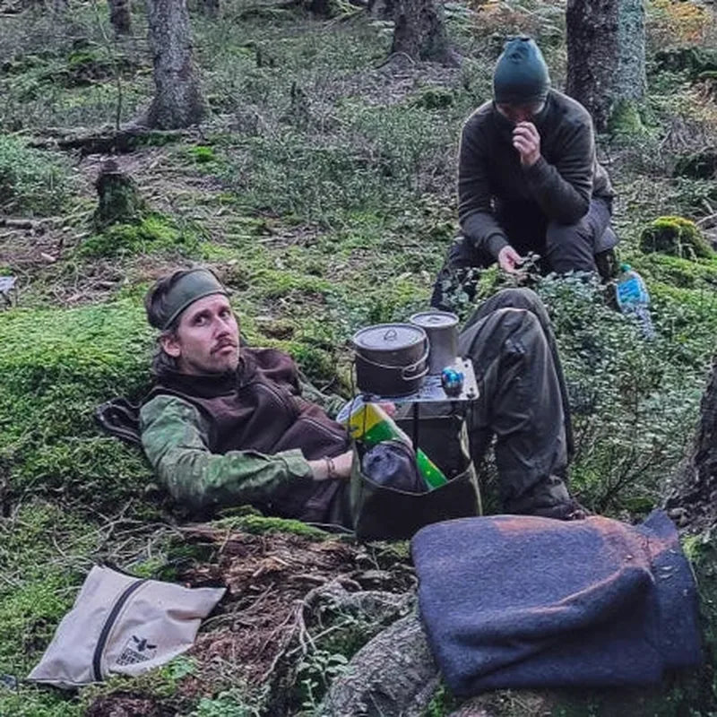 Bord i mossig skog med kökskärl och förvaring